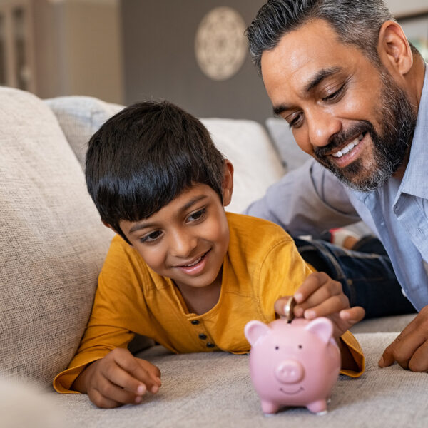 Father and son playing with piggy bank