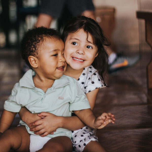 Young girl hugging her brother